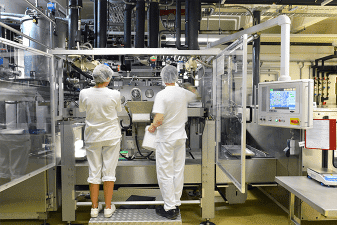 production of pralines in a factory for the food industry conveyor belt worker with chocolate 3868768